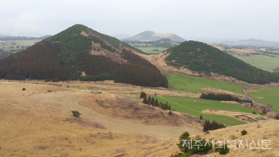 새별오름에서 본 이달오름과 이달이촛대봉 모습이다. 이웃집처럼 나란히 있다. 오름은 독립체를 이룬 건물과 같다. 하나의 가정을 이루고 있다. 건물 주변은 커다란 평원으로 이뤄진 정원이다. (2018년 3월 7일 현지에서)
